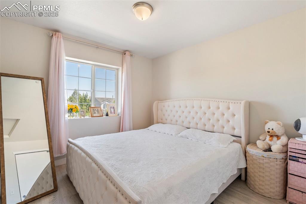 Image 18 of 25: Bedroom featuring light wood-style floors