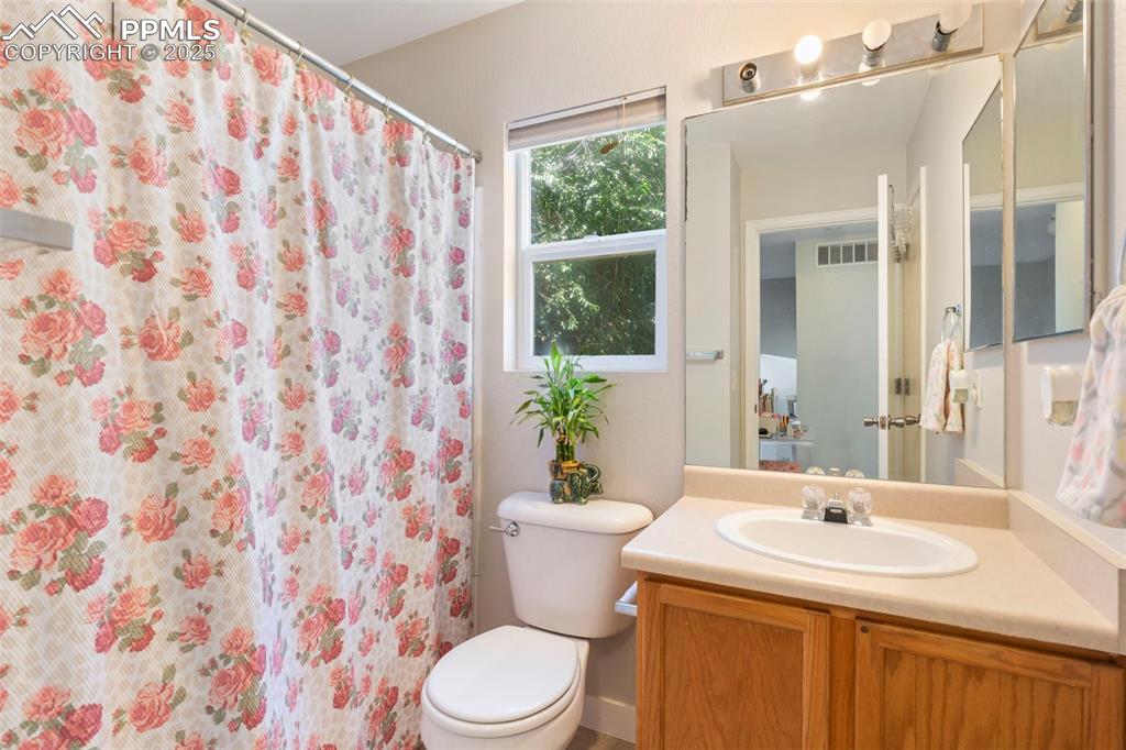 Image 20 of 25: Bathroom with vanity and a shower with shower curtain