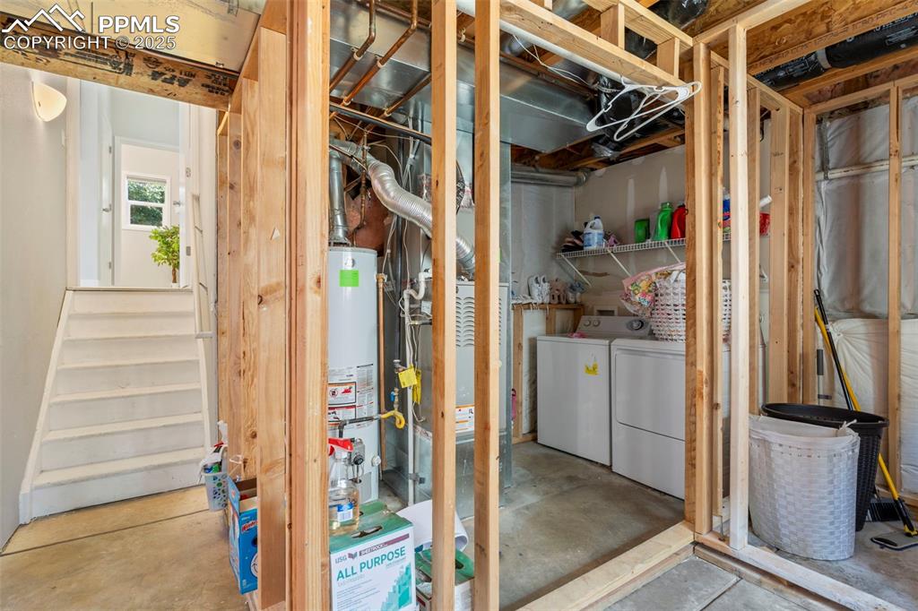 Image 23 of 25: Below grade area with independent washer and dryer and gas water heater