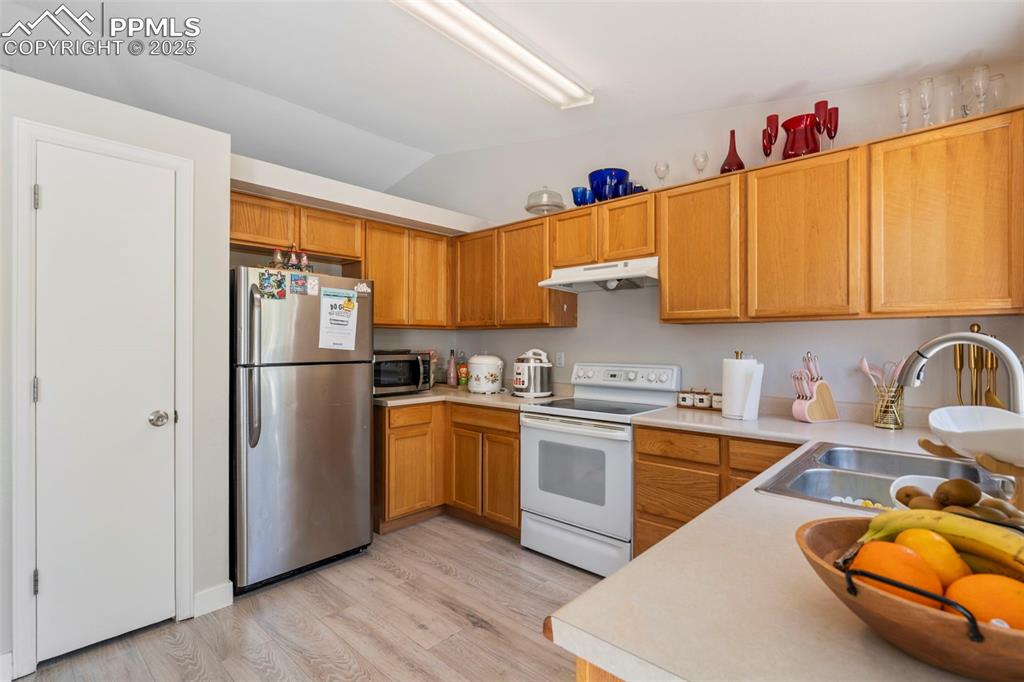 Image 8 of 25: Kitchen with light countertops, appliances with stainless steel finishes, v