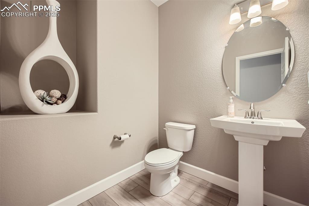 Image 13 of 30: Even the half bath has custom shelving!
