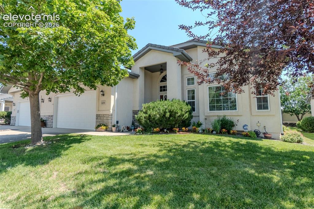 Caption: Stucco exterior featuring stone accents with beautiful flowers and curb appeal