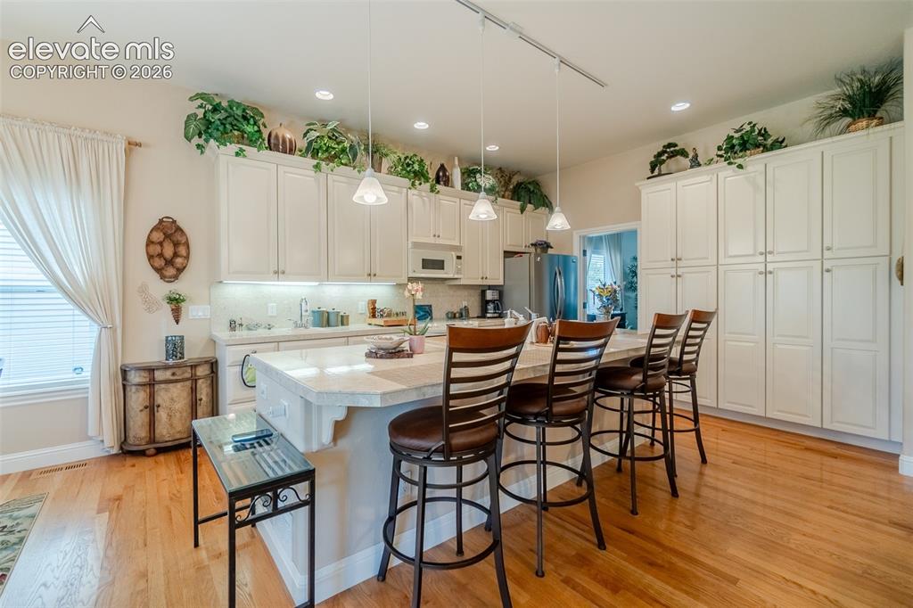 Image 10 of 47: Spacious kitchen featuring an expansive center island with seating, extensi