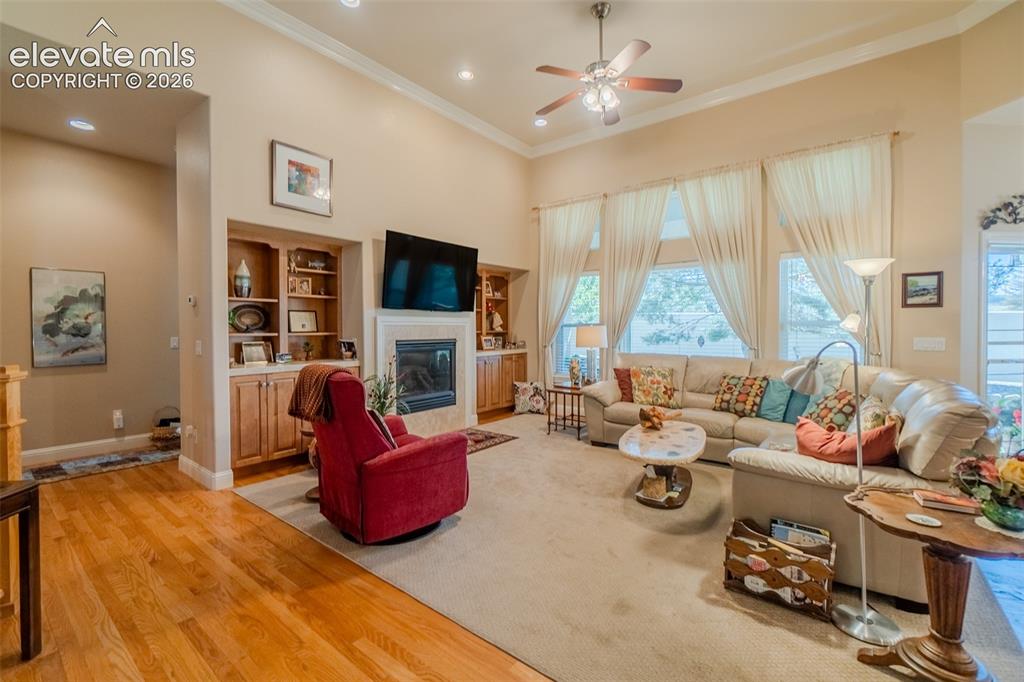 Image 13 of 47: Spacious living room featuring a vaulted ceiling with crown molding, a ceil