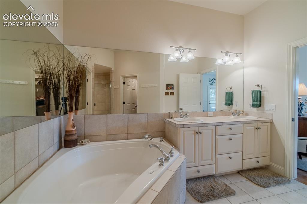 Image 18 of 47: Spacious bathroom featuring a corner soaking tub, dual vanity with undermou