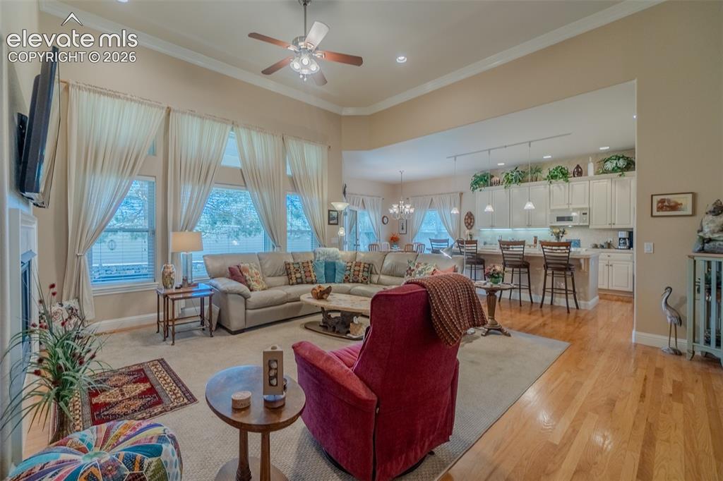 Image 20 of 47: Expansive living area featuring vaulted ceilings, ceiling fan, and multiple