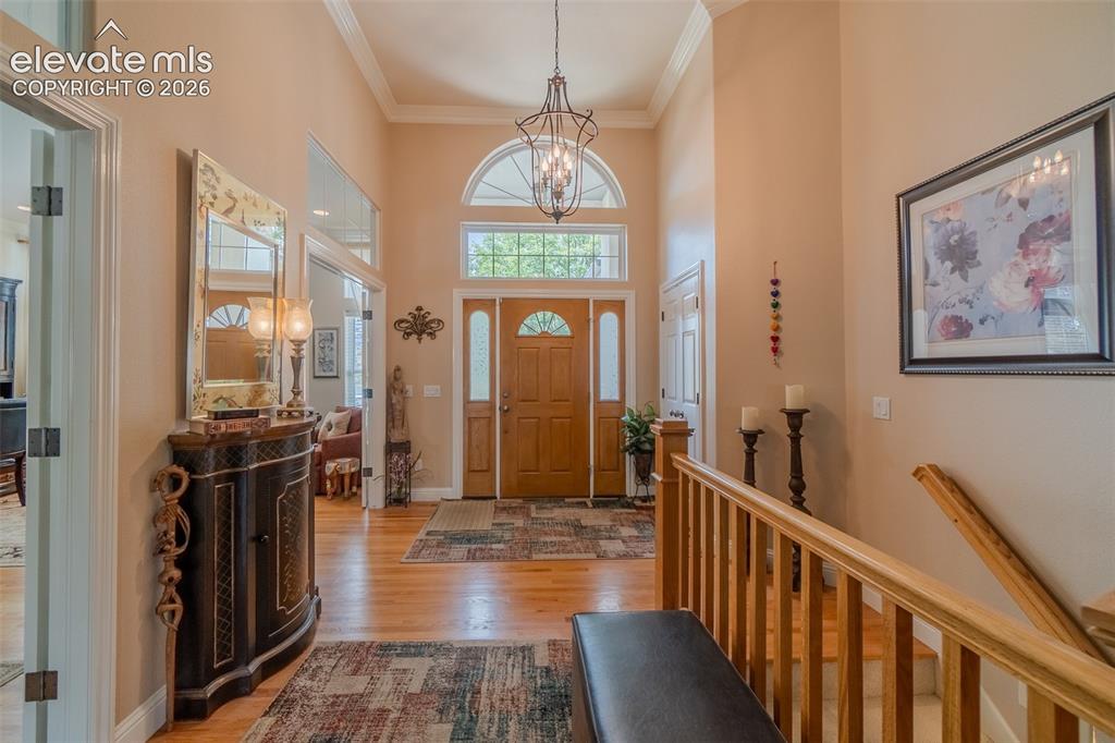 Image 21 of 47: Foyer featuring a tall arched transom window, wood-finish flooring, a grand