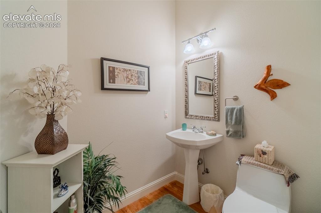 Image 23 of 47: Guest Bathroom Pedestal sink with chrome-finish faucet, framed mirror, and