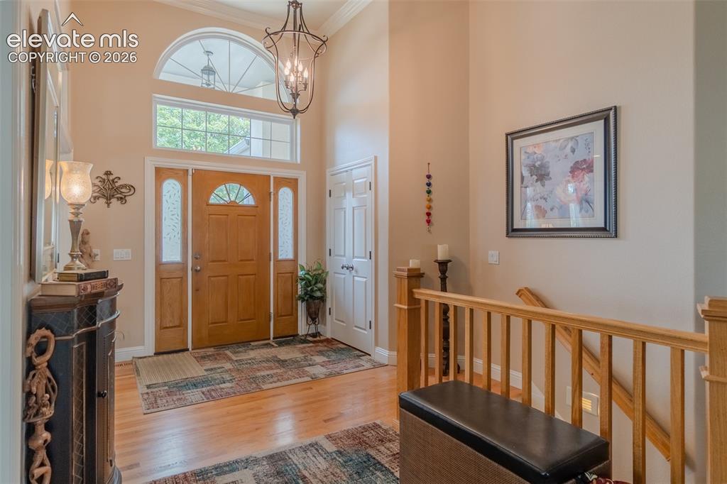 Image 24 of 47: Two-story foyer featuring an arched transom window, wood-finish flooring, a