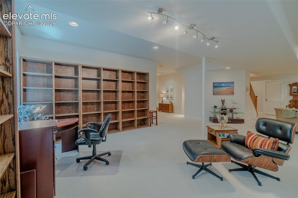 Image 37 of 47: Expansive lower-level space featuring extensive built-in wooden shelving, t