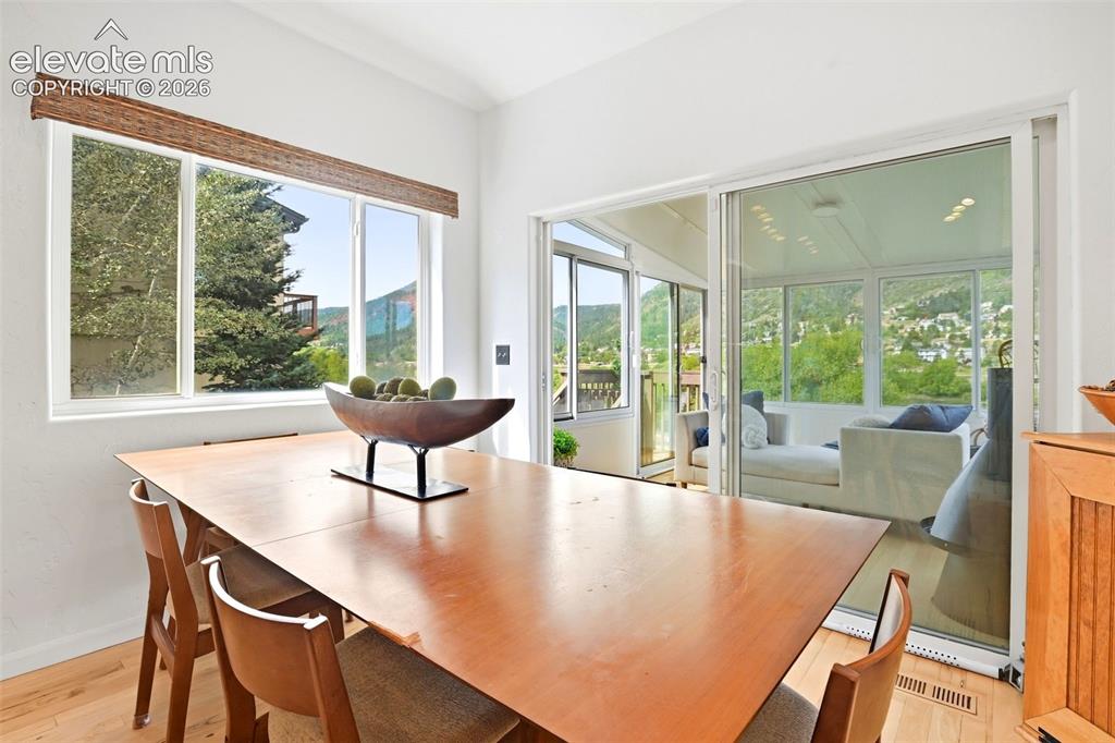 Image 15 of 49: White vaulted ceilings, light wood-finish flooring, and large windows