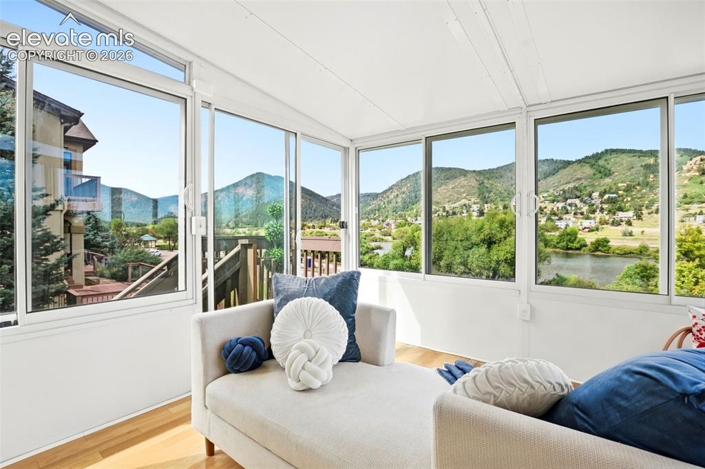 Image 20 of 49: Bright sunroom featuring multiple large windows, wood-finish flooring, and