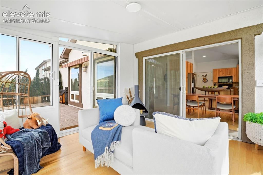 Image 21 of 49: Wood-finish flooring with multiple sliding glass doors and a ceiling-mounte