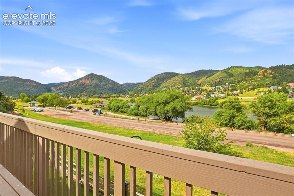Image 25 of 49: Expansive outdoor space with wood railing, offering a scenic backdrop of mo