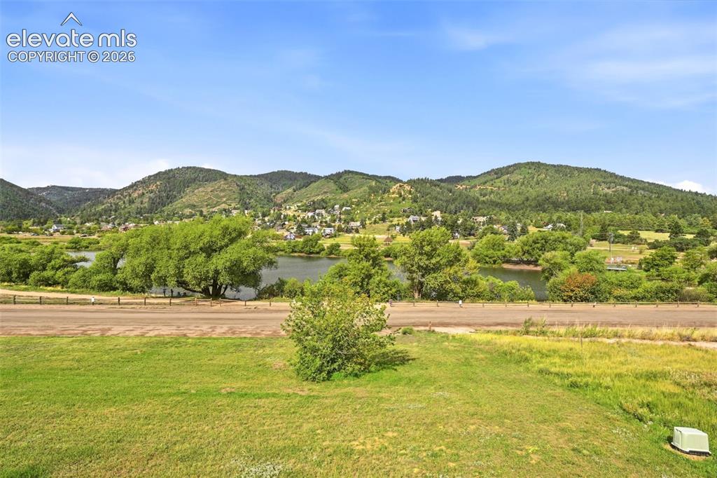 Image 26 of 49: Expansive natural scenery featuring a body of water, lush green vegetation,