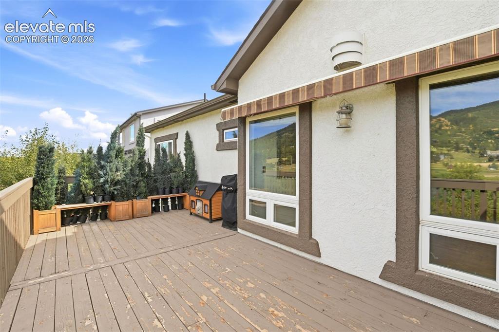 Image 27 of 49: Expansive outdoor deck with a wood railing and built-in planters