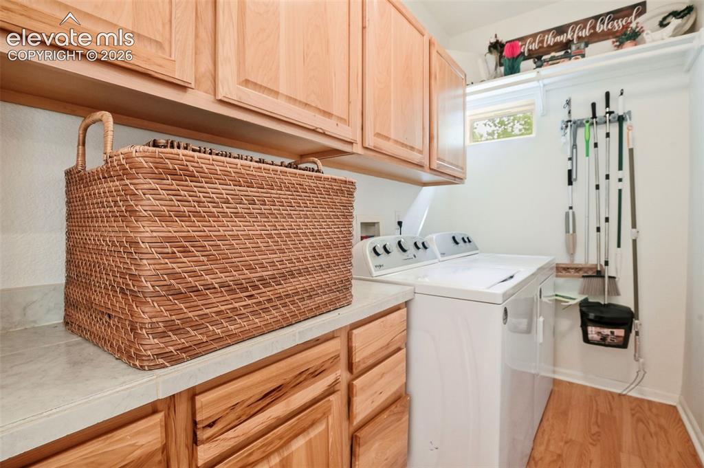 Image 33 of 49: Built-in wood cabinetry with light-toned wood-finish flooring, a white coun