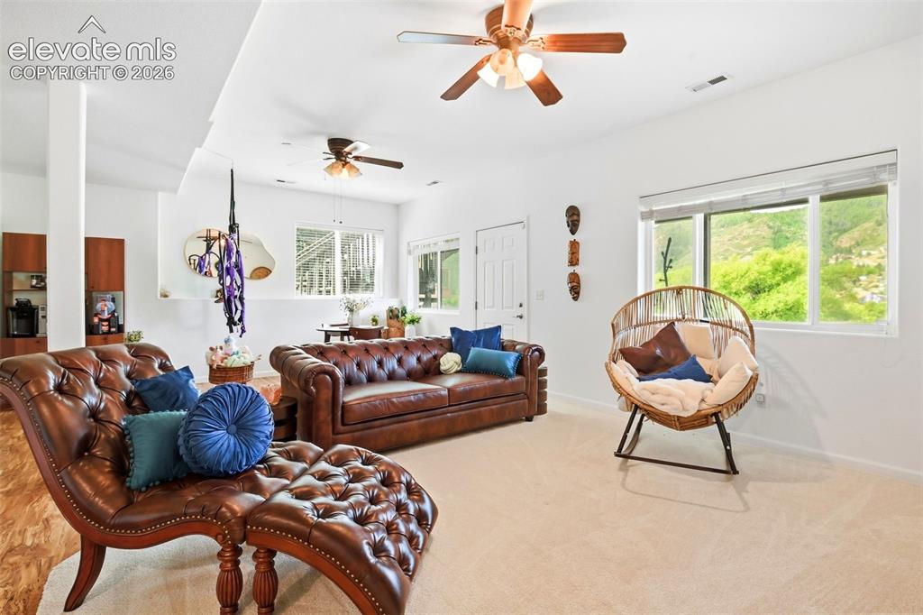 Image 42 of 49: Spacious open-concept living area featuring light-colored carpeting and whi