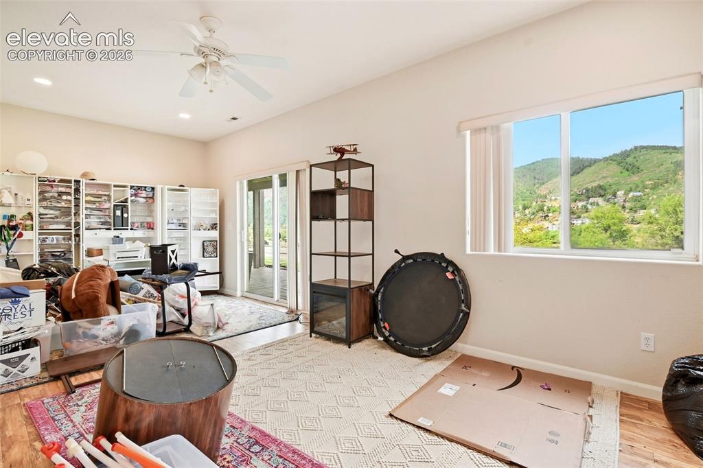 Image 45 of 49: Sliding glass door to exterior, large window, ceiling fan, recessed lightin