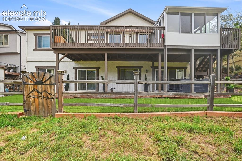 Image 47 of 49: Multi-level outdoor living space featuring an upper-level wood deck, a lowe