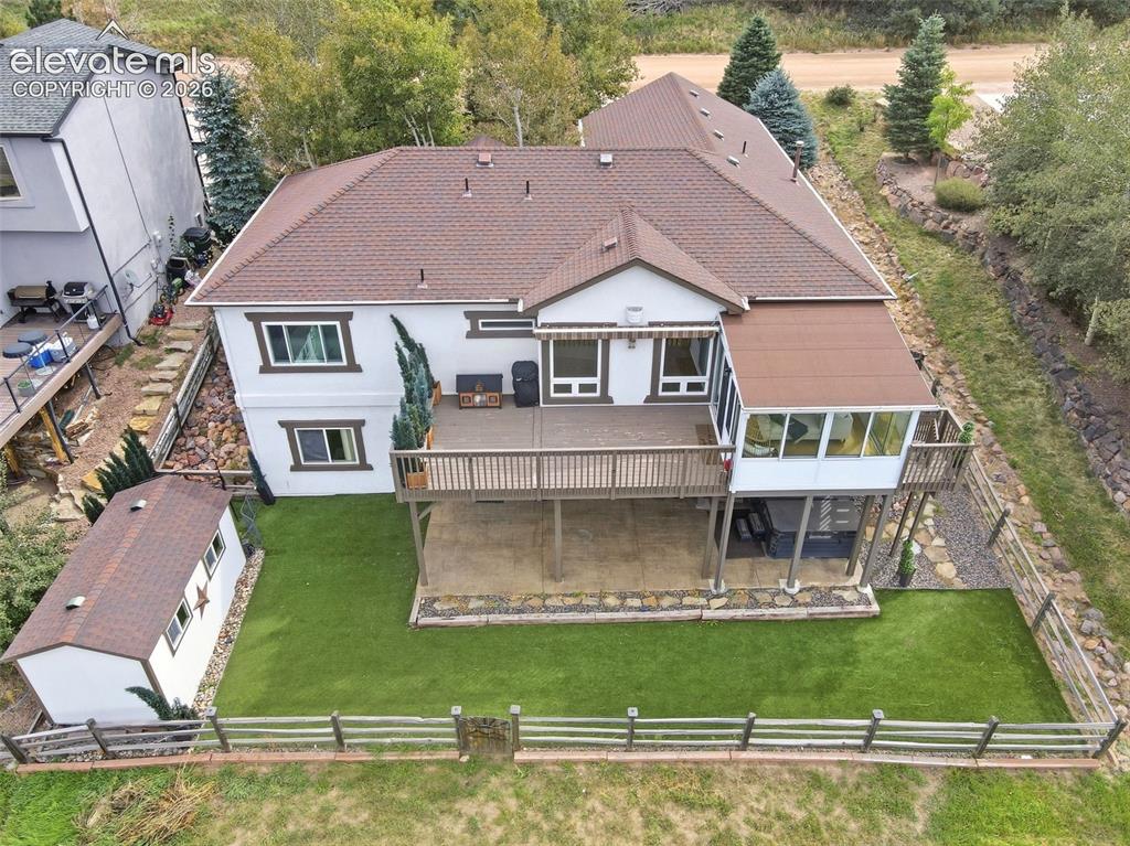 Image 48 of 49: Multi-level exterior with a large deck, enclosed sunroom, low-maintenance a