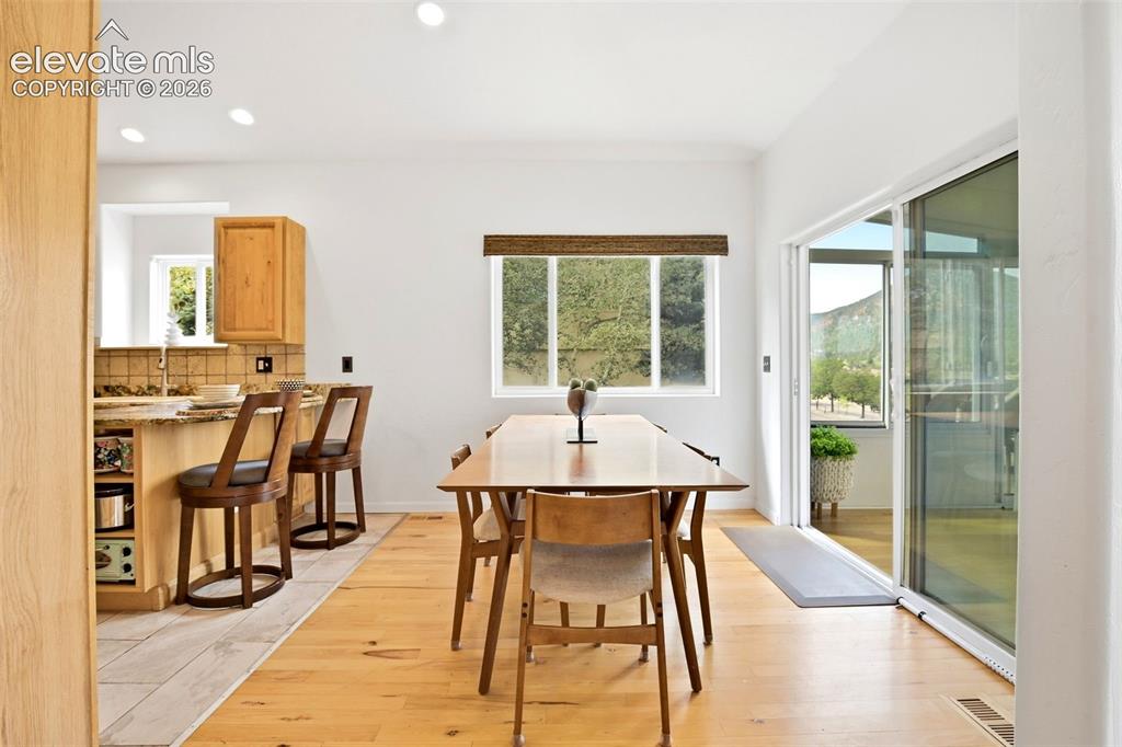 Image 6 of 49: Dining area leads out to the enclosed sunroom.