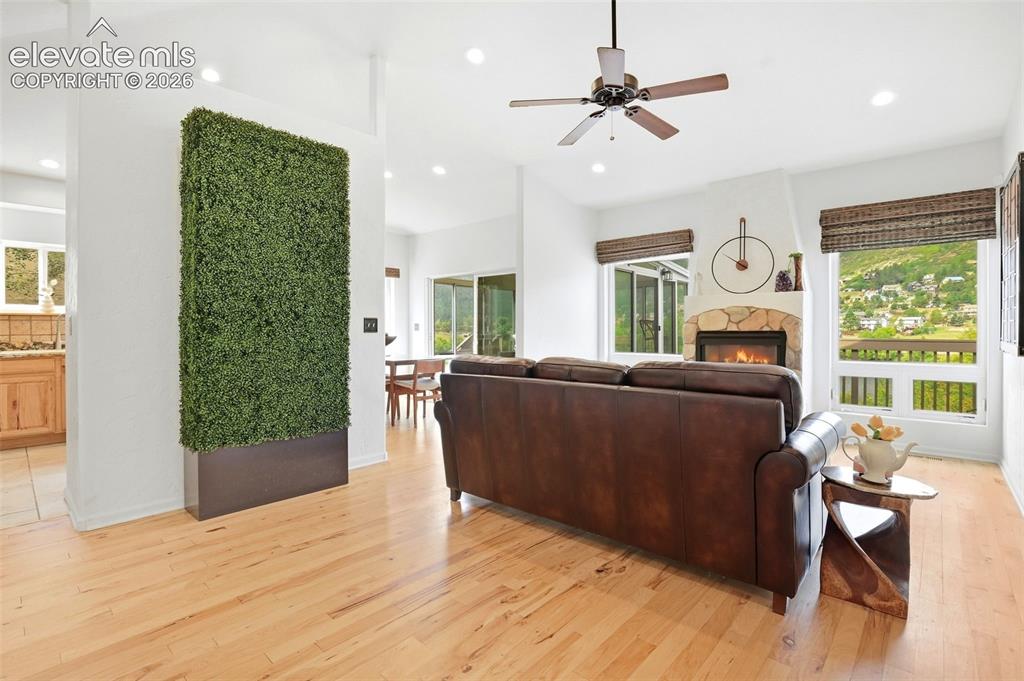 Image 9 of 49: Hardwood flooring throughout the living area, stone fireplace with hearth,