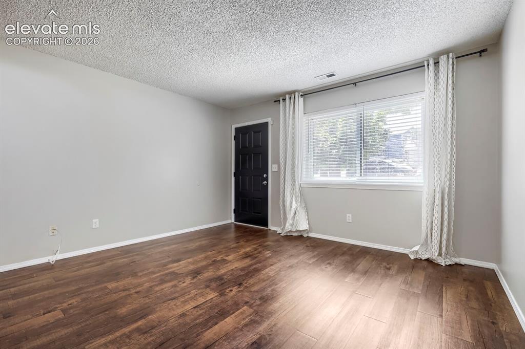 Image 10 of 28: Living space featuring wood-finish flooring, a fireplace with decorative ti