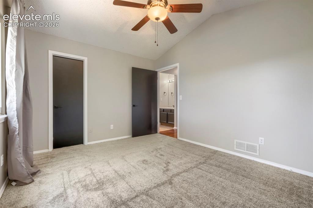 Image 14 of 28: Vaulted ceiling room with ceiling fan light fixture, gray carpet flooring,