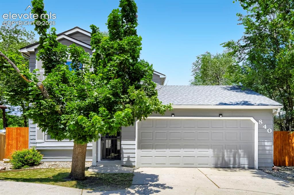 Image 2 of 28: Contemporary exterior featuring gray siding, a light gray garage door with