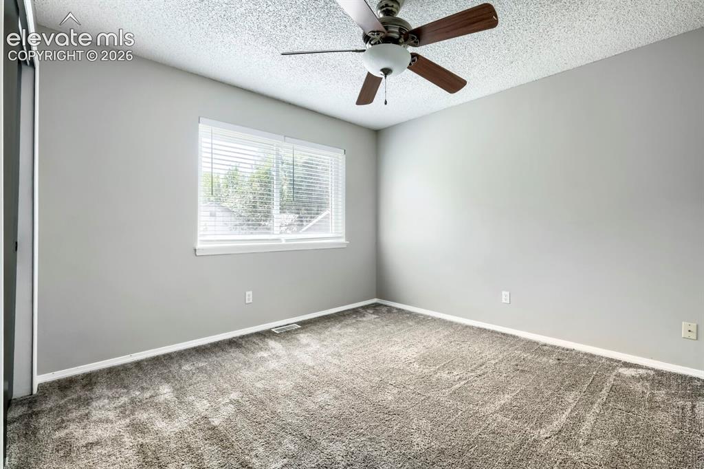Image 21 of 28: Light gray walls complement the textured gray carpeting in this room featur
