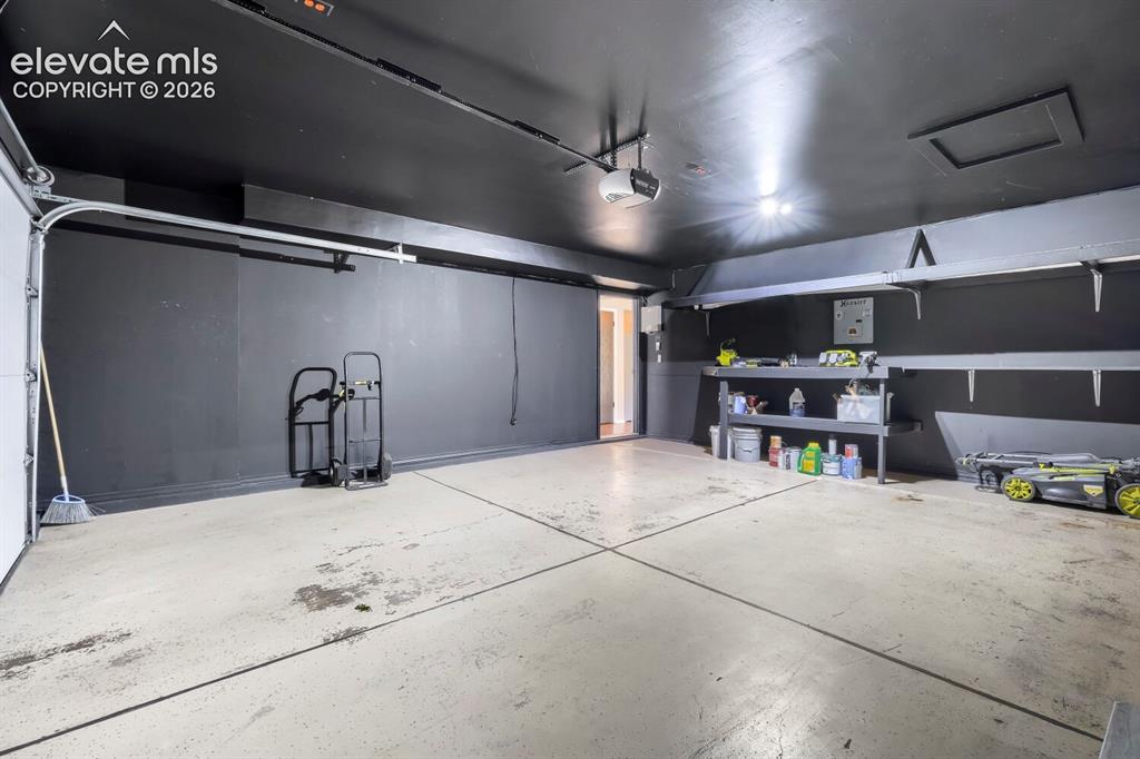 Image 24 of 28: Garage with work bench and storage