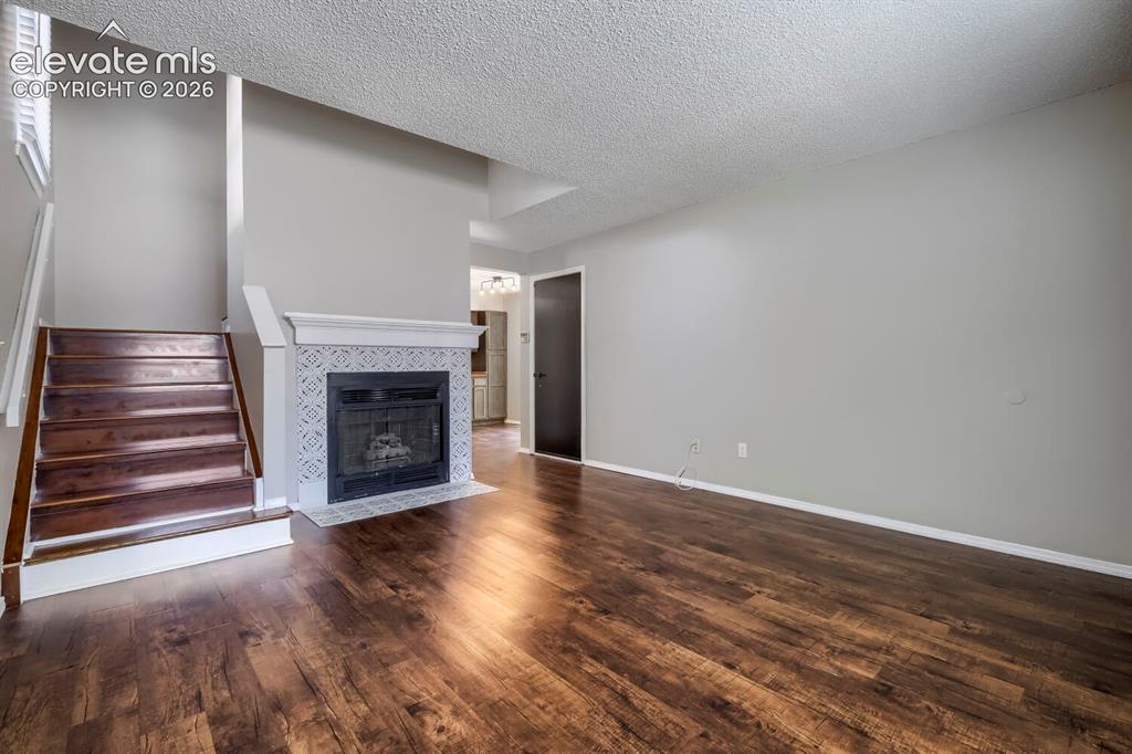 Image 4 of 28: Living space featuring wood-finish flooring, a fireplace with decorative ti