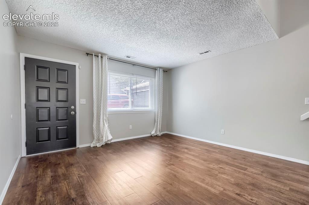 Image 5 of 28: Living space featuring wood-finish flooring, light gray wall paint, and a t