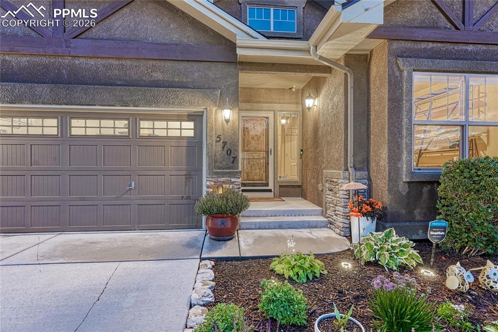Image 2 of 50: The front entryway features custom stonework and a charming path that guide