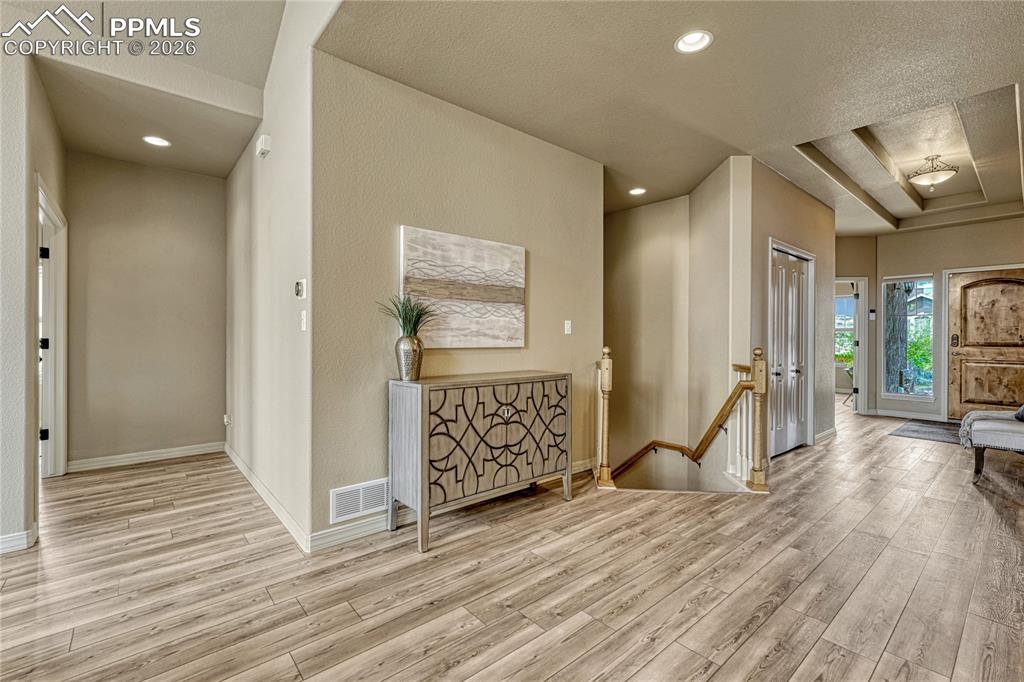 Image 25 of 50: Luxury vinyl plank flooring continues gracefully down the hall, leading to 