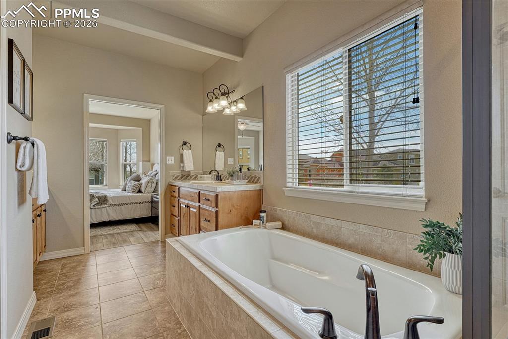 Image 29 of 50: Unwind in the 5-piece en-suite featuring a deep soaking tub positioned perf