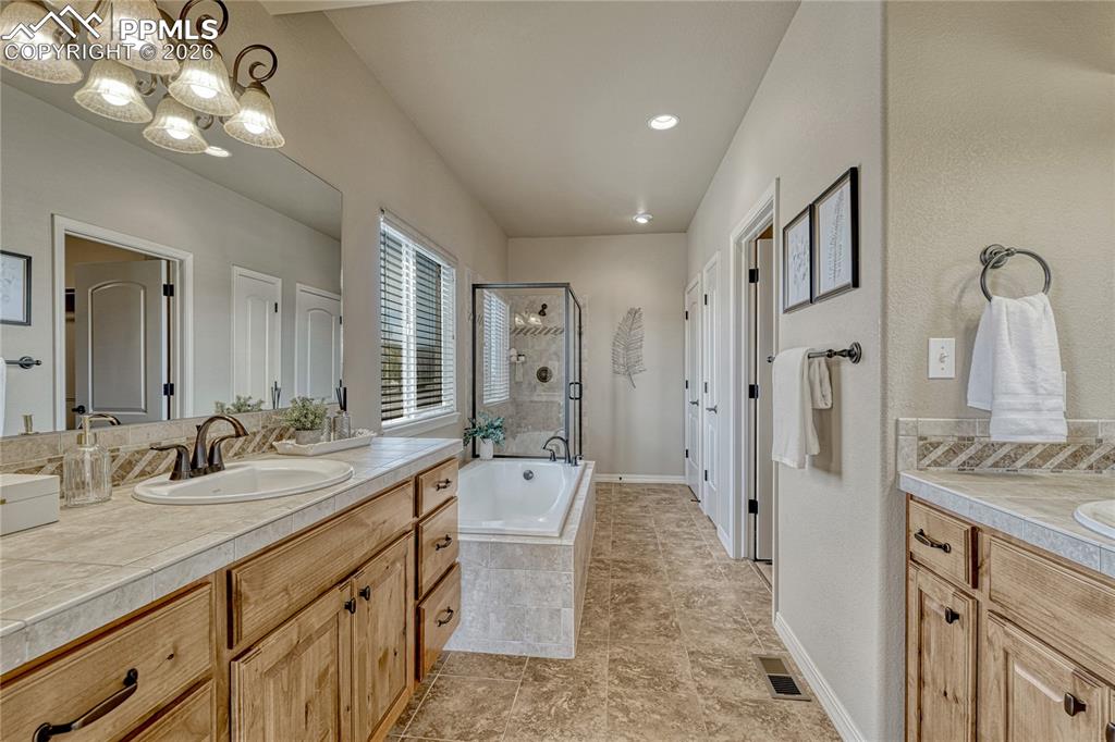 Image 30 of 50: Dual vanities and a separate free-standing shower complete the primary bath
