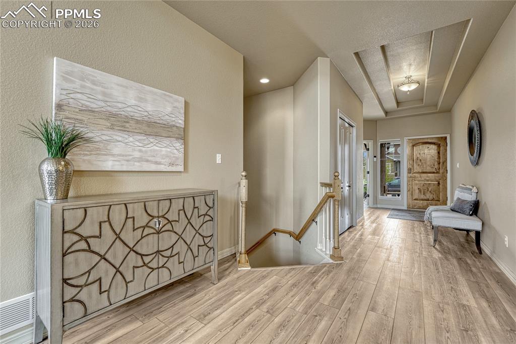 Image 32 of 50: The open stairwell features elegant wood detailing, inviting you down to ex