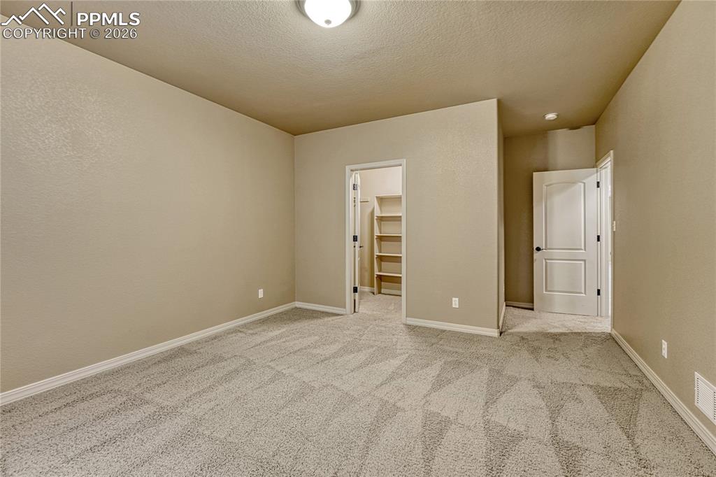 Image 35 of 50: This large basement bedroom is perfectly sized for guests or family and inc