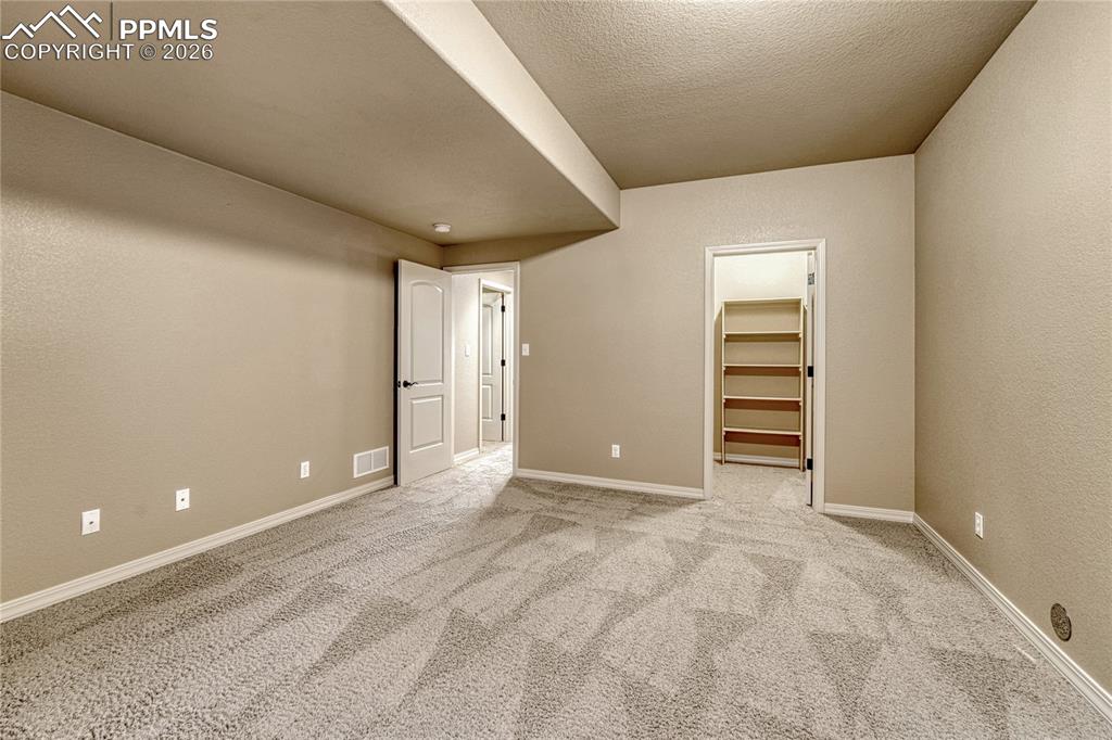 Image 37 of 50: A second basement bedroom offers privacy, plush carpeting, and another siza
