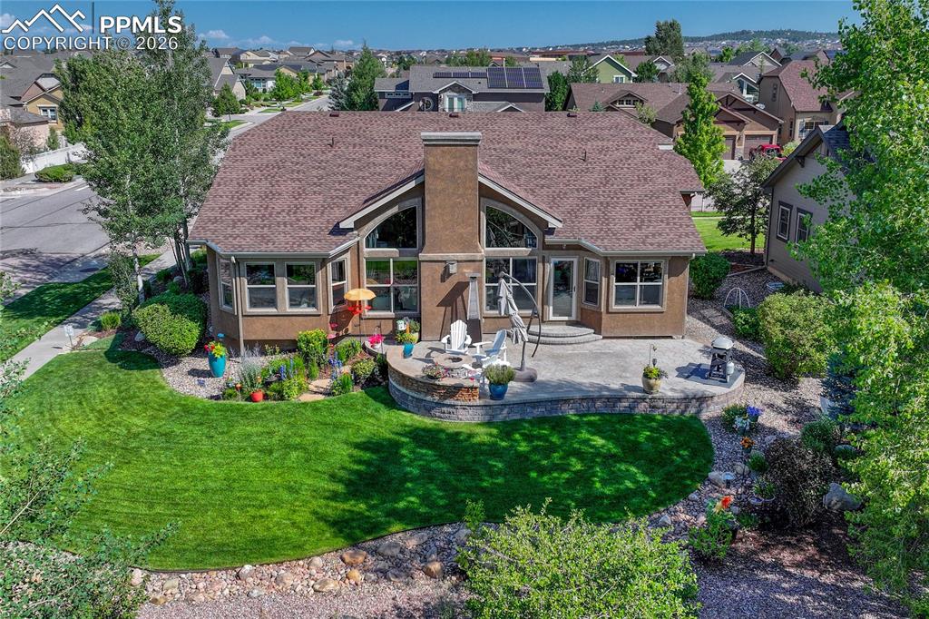 Image 46 of 50: An aerial view highlights the expansive custom patio and beautiful backyard