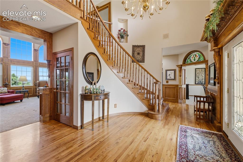 Image 11 of 49: Hardwood flooring extending through the foyer, curved wooden staircase with