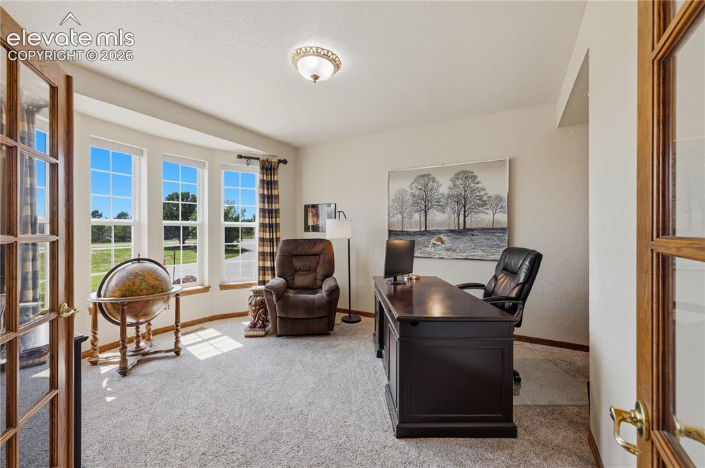 Image 22 of 49: Office 1 of 2 - Room with a bay window, wood-frame French doors, and ceilin