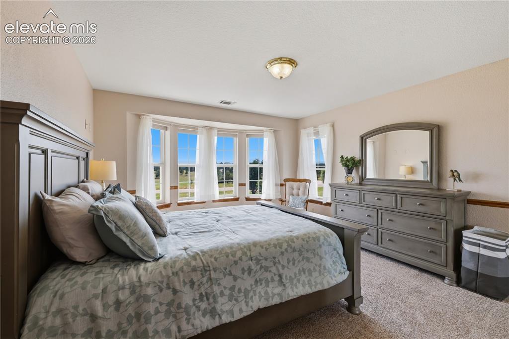Image 27 of 49: Upstairs Bedroom, - neutral carpet, and a flush mount light fixture