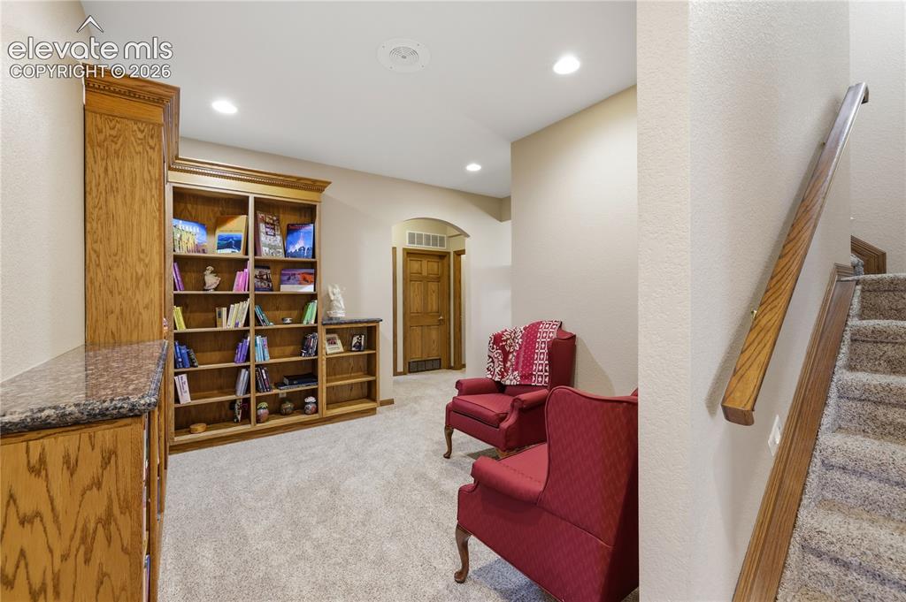 Image 30 of 49: Built-in wood cabinetry with stone countertops, integrated shelving, and re