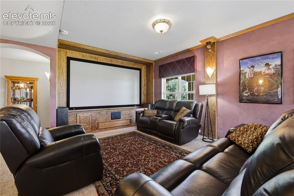 Image 33 of 49: Media room featuring a large projection screen, built-in sound system, and
