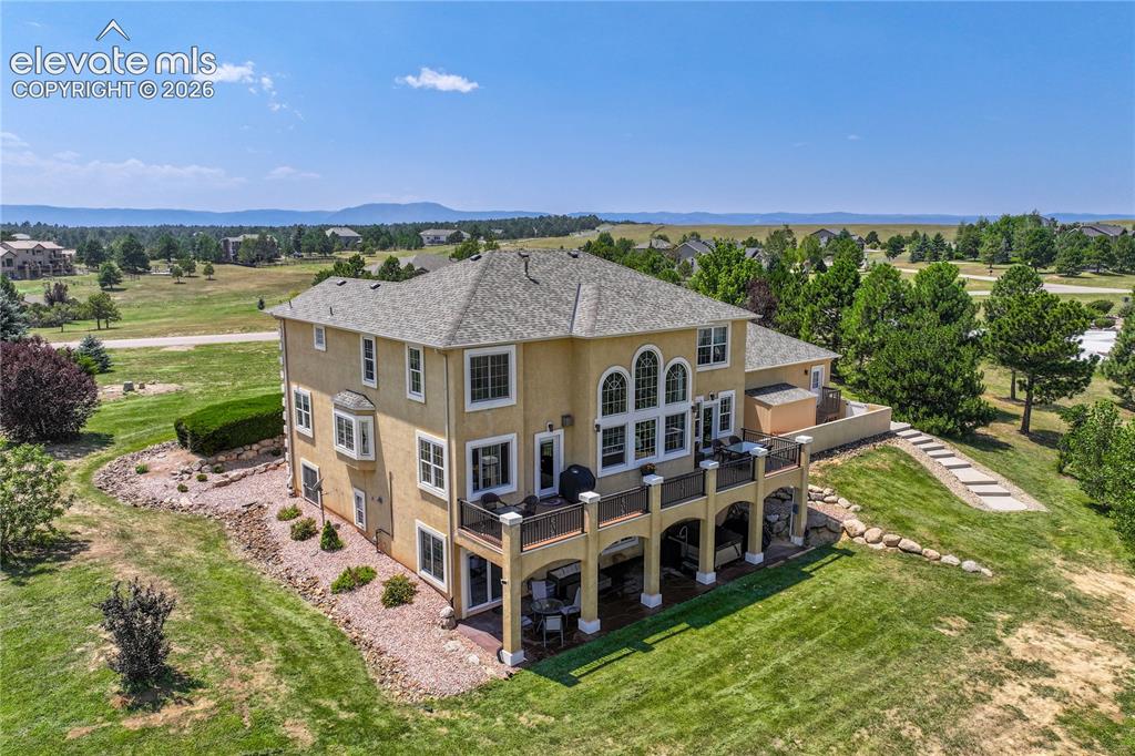 Image 5 of 49: Stucco exterior with a multi-level deck, bay window, arched windows, and a 