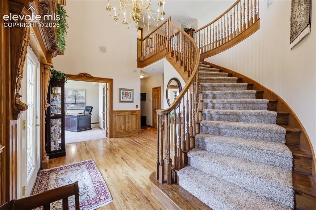 Image 9 of 49: Elegant foyer featuring a curved wooden staircase with spindle railings, ha