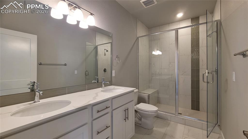 Image 20 of 36: Primary Bathroom with double vanities, quartz countertop, shower with bench